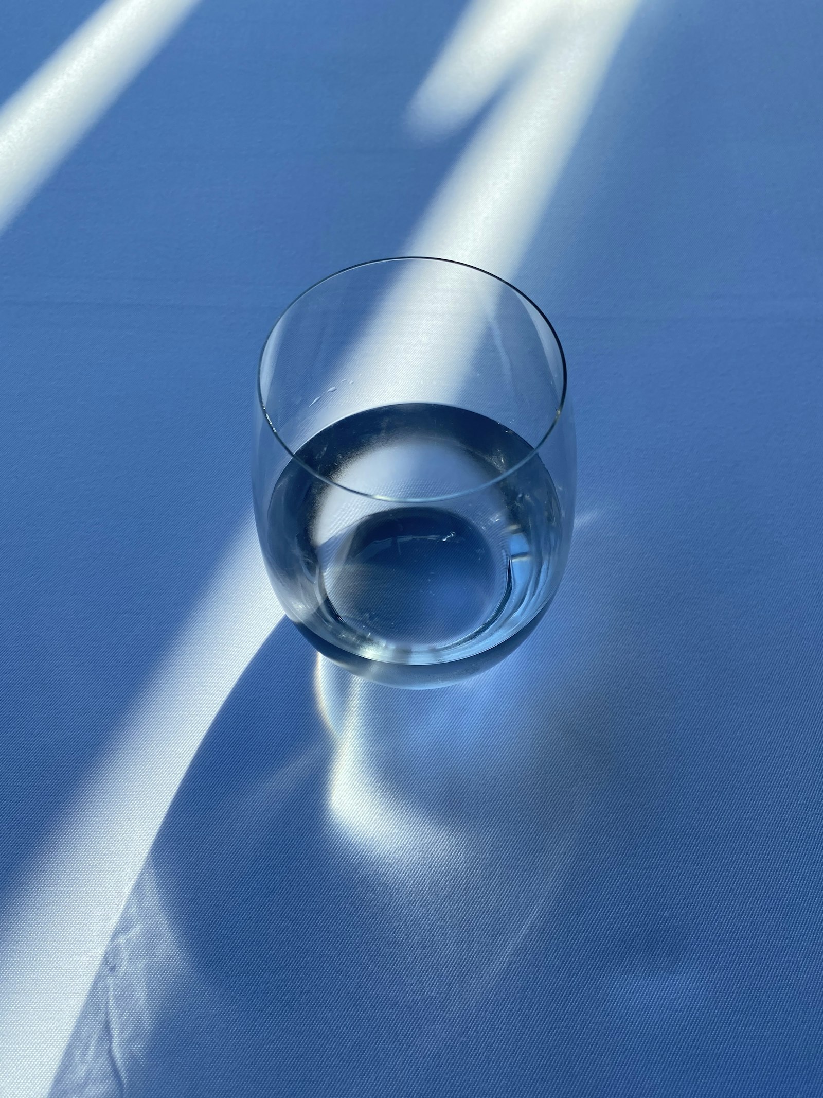 Clear glass of water with reflections, representing the risk of drinking too much plain water