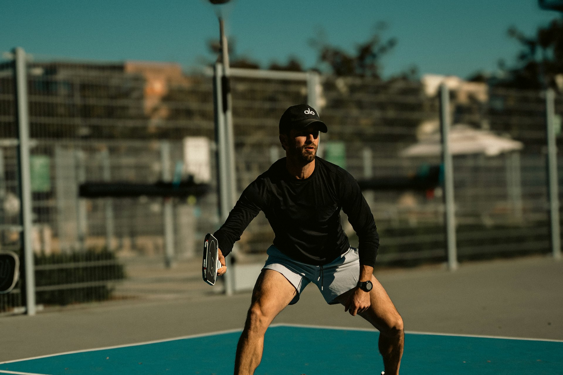 Pickleball player in ready position on outdoor court