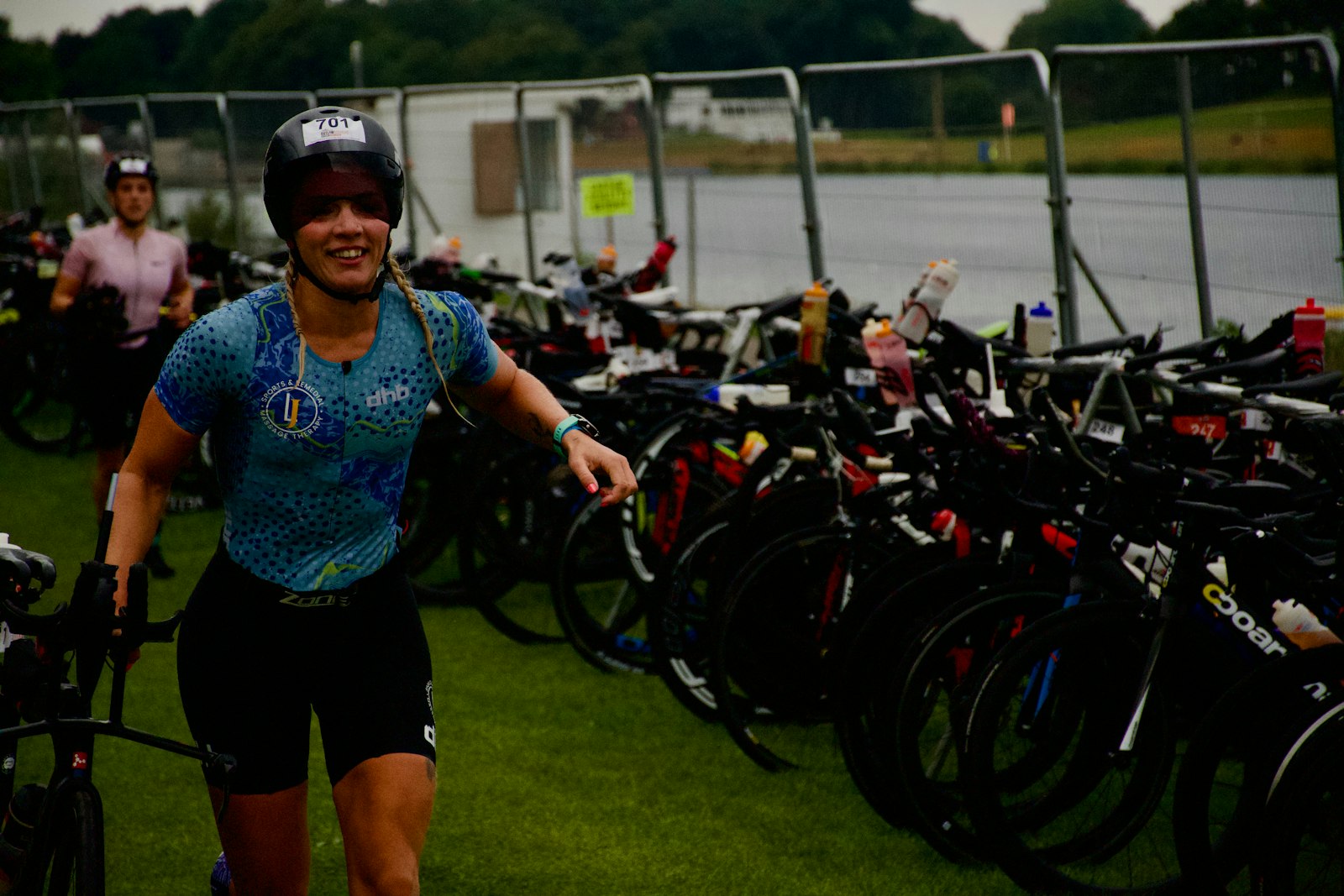 Female triathlete in transition area racking next to her bike