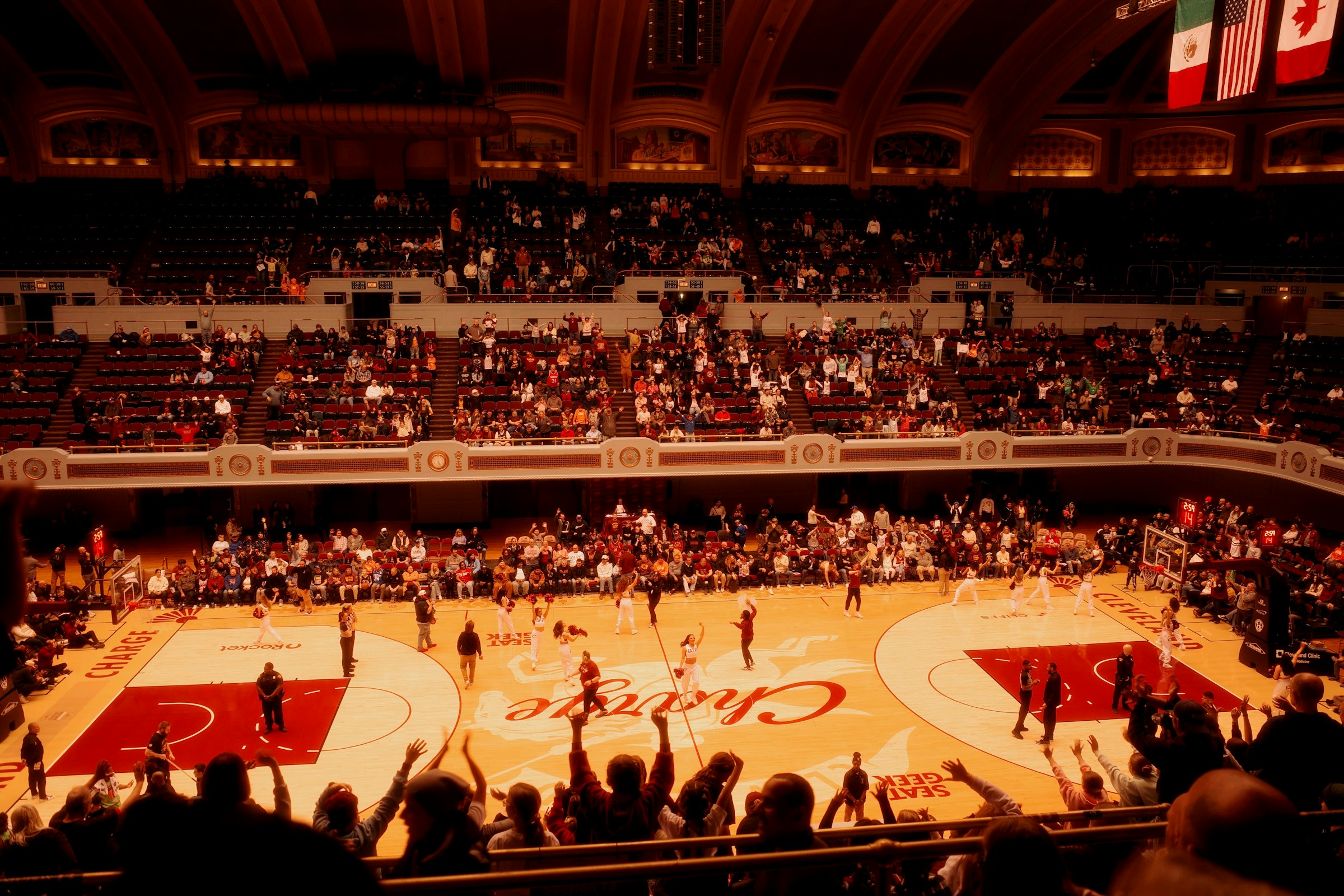 Basketball game in a packed arena with cheering crowd at night during a competitive game.