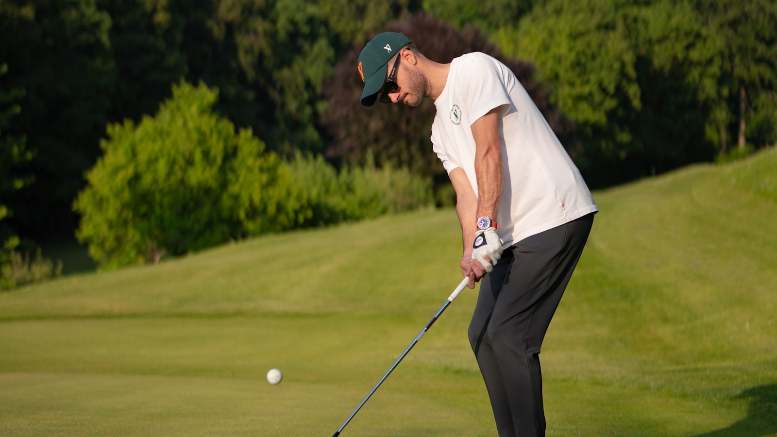 Male golfer playing a round on a green summer course — illustrating golf hydration and electrolyte demands of a 4-hour summer round