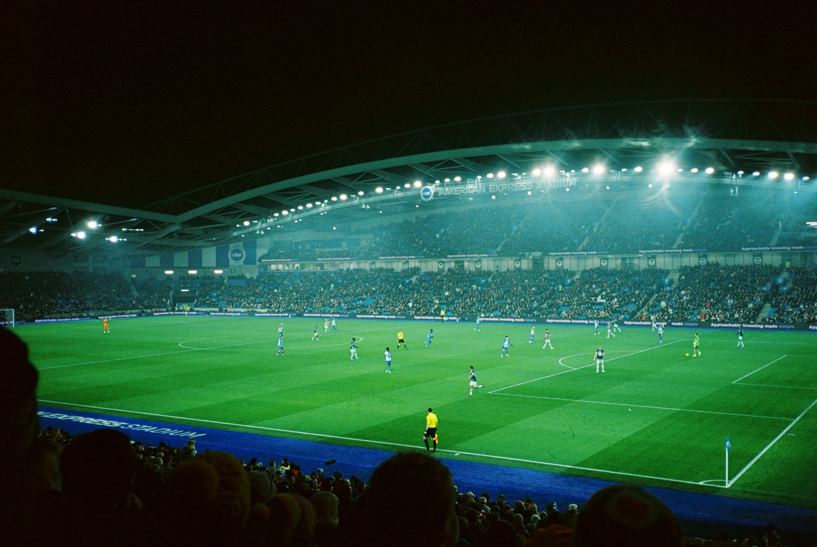 Soccer match in a packed night stadium under floodlights