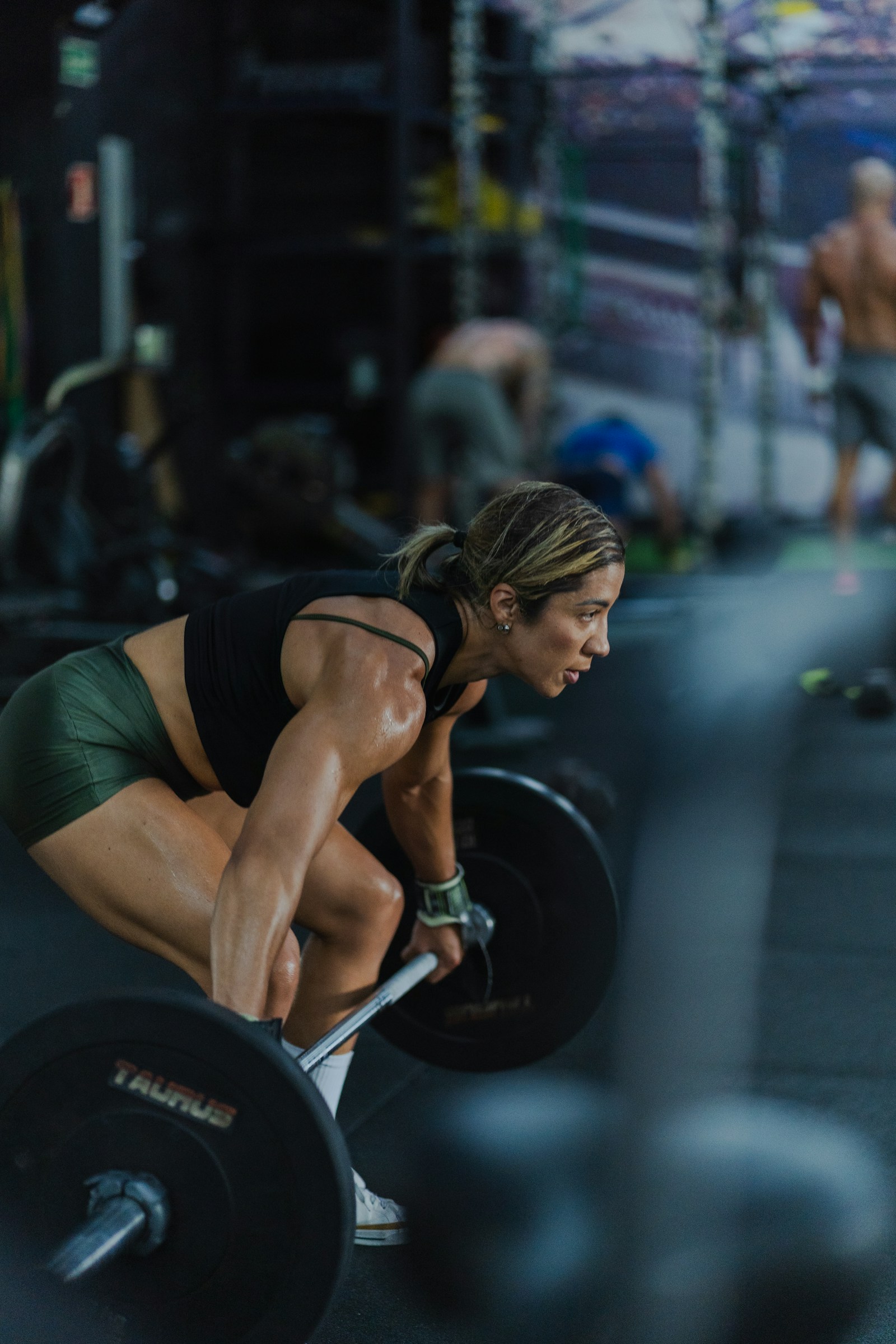 Female strength athlete preparing for a heavy deadlift in a gym
