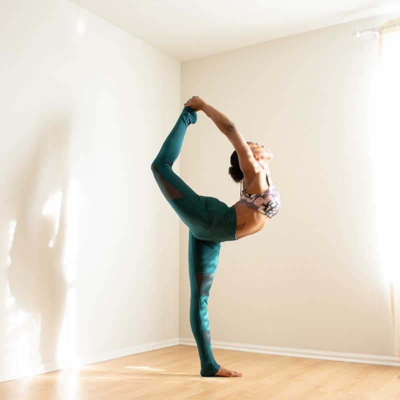 Woman in dancer yoga pose in a bright studio — illustrating hot yoga hydration and electrolyte demands of a Bikram class