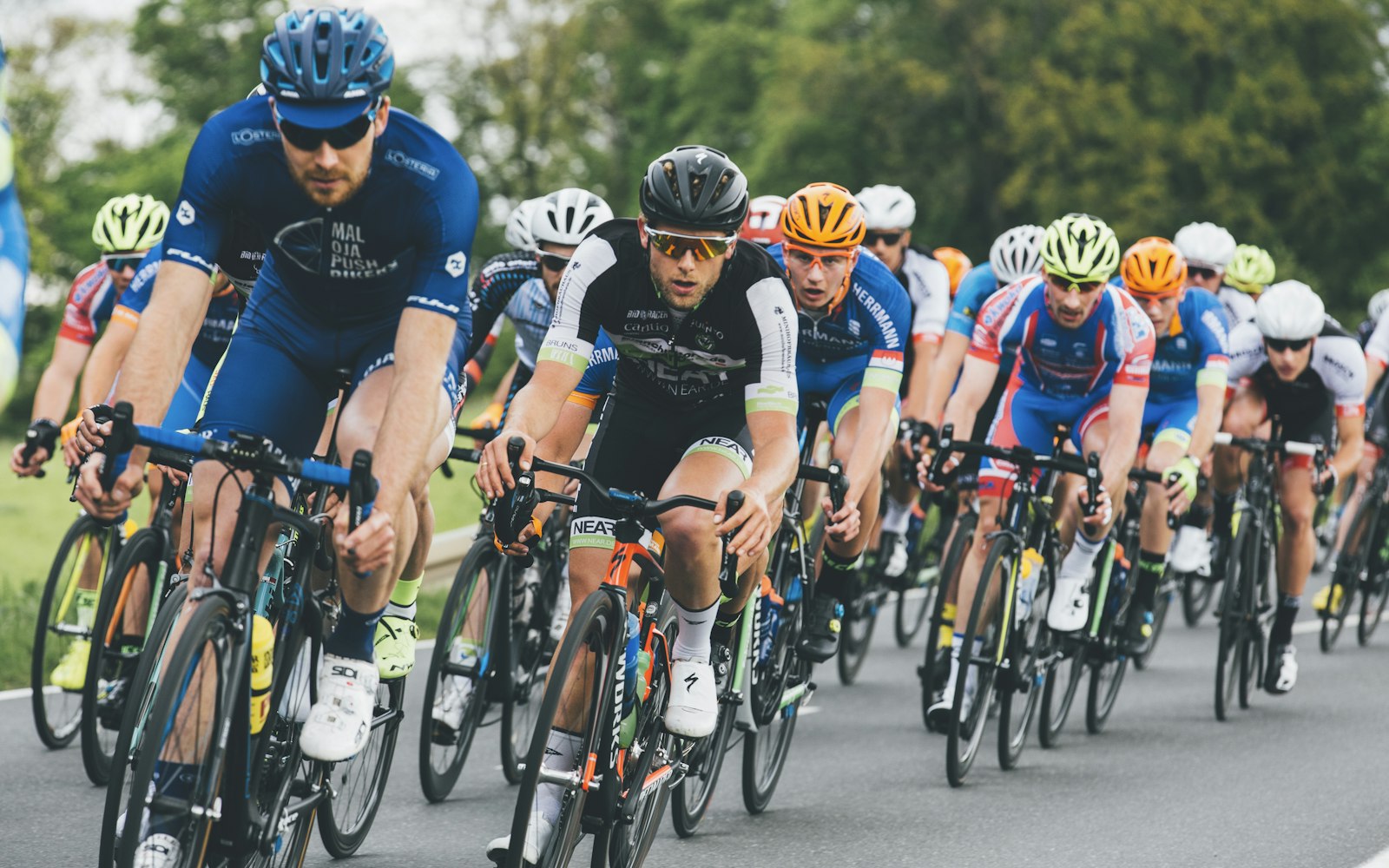 Peloton of cyclists racing in a road cycling competition — illustrating the intense hydration demands of Tour de France stage racing