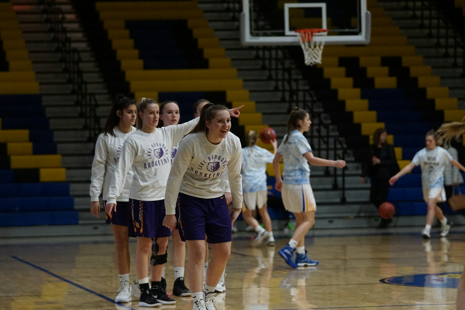 Group of women basketball players on an indoor court — illustrating WNBA and women's basketball hydration needs during the summer season.