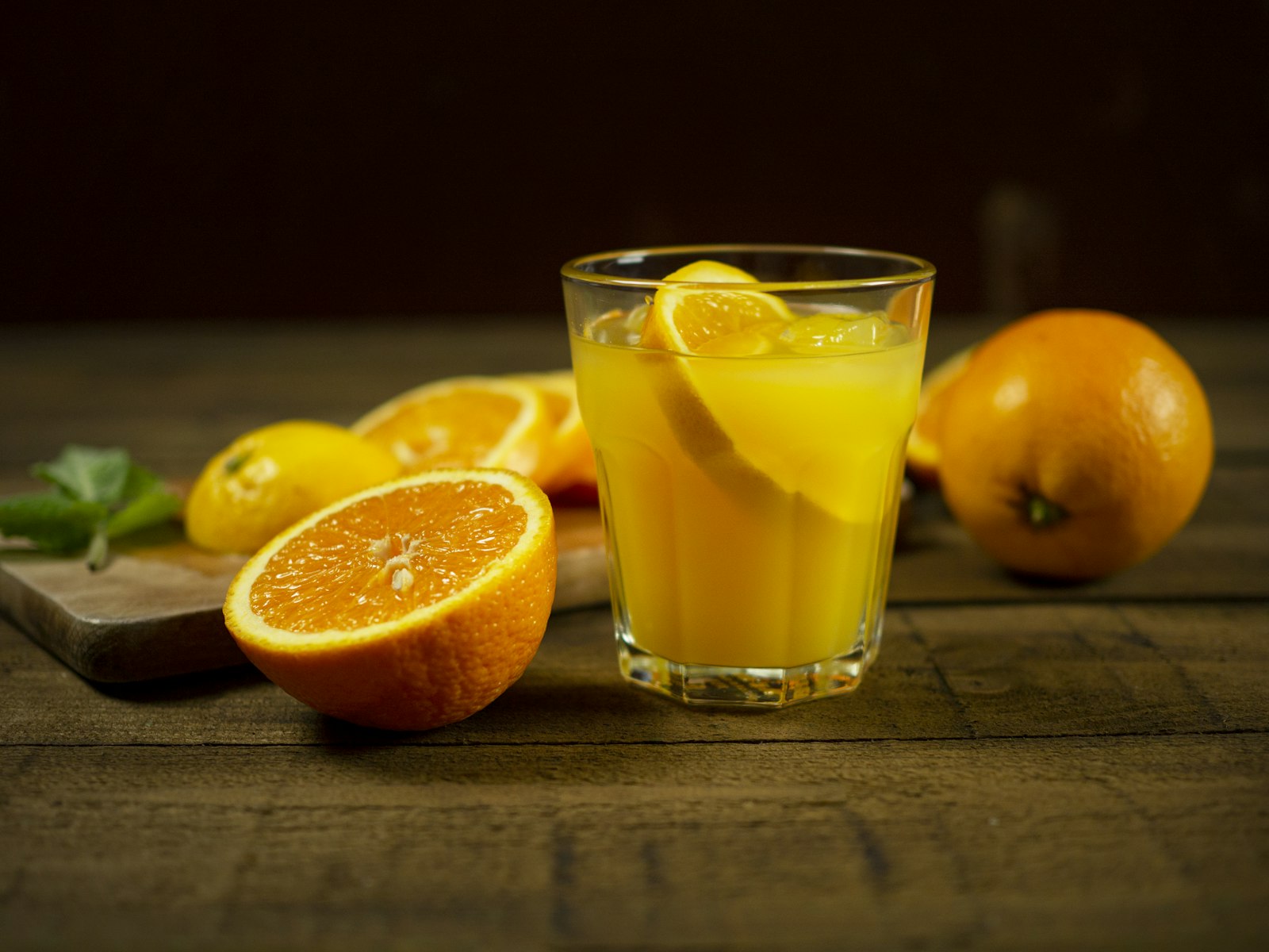 Glass of orange juice beside a bottle of water on a table