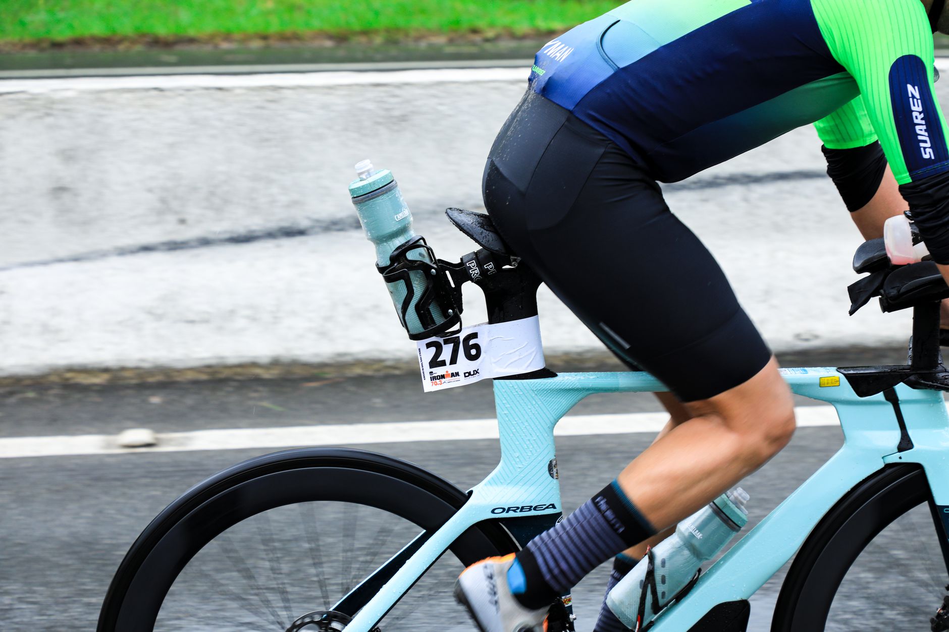 Close-up of a triathlete on a bicycle during a race, showcasing athletic gear and speed.