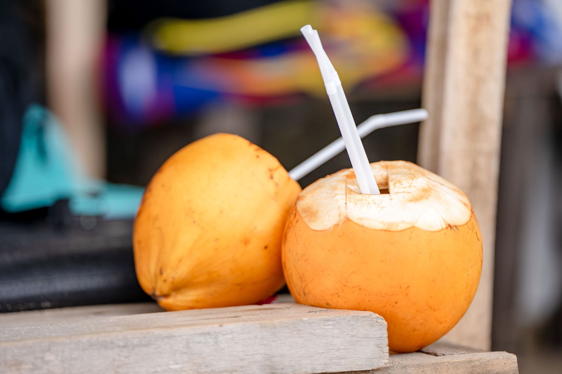 Close-up of fresh yellow coconuts with drinking straws, perfect for a tropical refreshment.