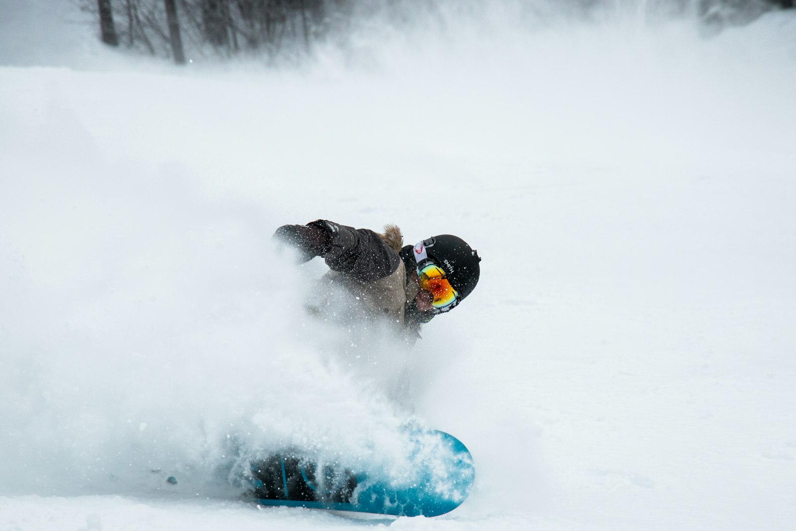 Snowboarder riding down a snowy mountain slope
