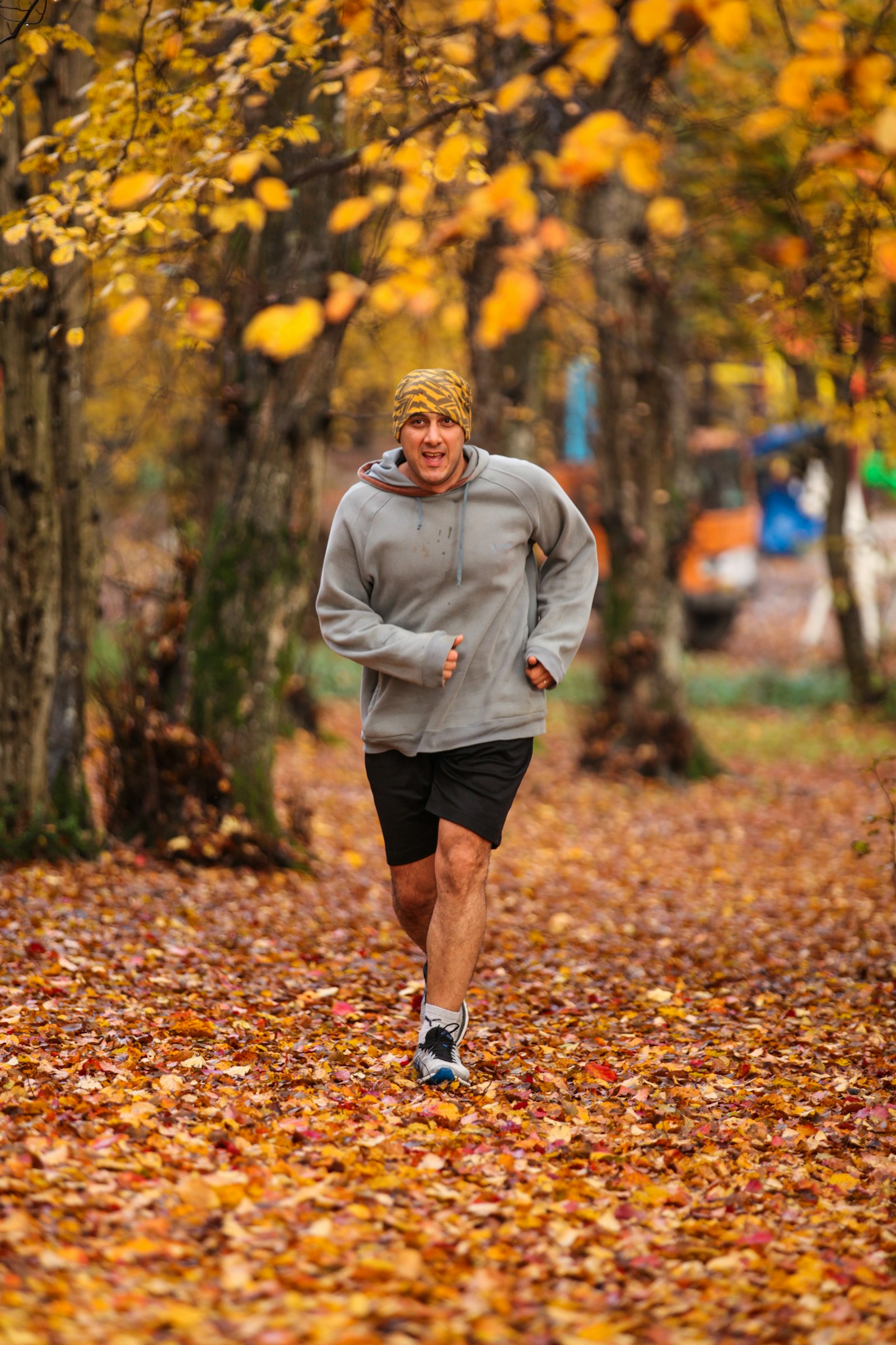 Runner on a leaf-covered trail on a crisp autumn morning